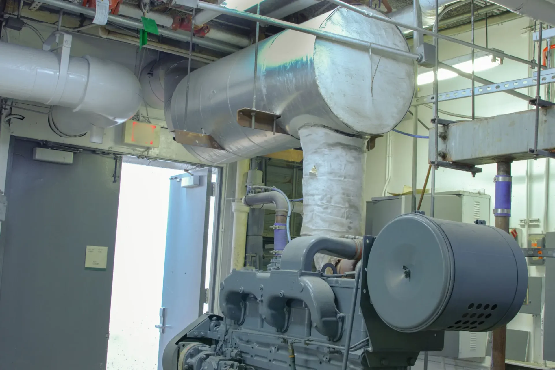 Industrial machinery and large exhaust pipes indoors.