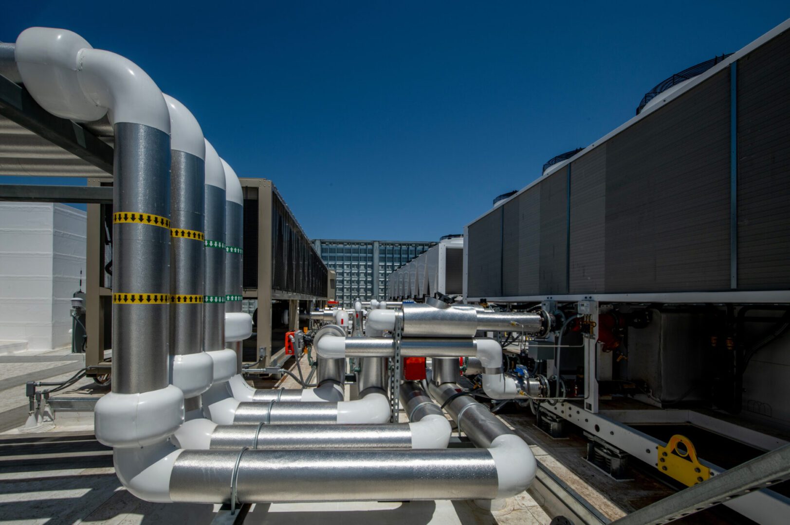 Industrial pipes and cooling units under sky.